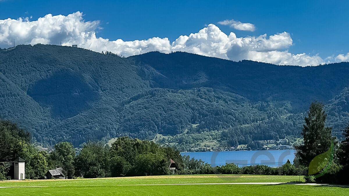 Malerische Landschaft mit bewaldeten Bergen und einem ruhigen See in der Ferne.