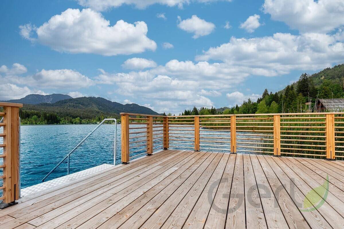 Geräumige Holzterrasse mit Geländer, direkt am See gelegen, ideal zum Sonnenbaden und Entspannen.