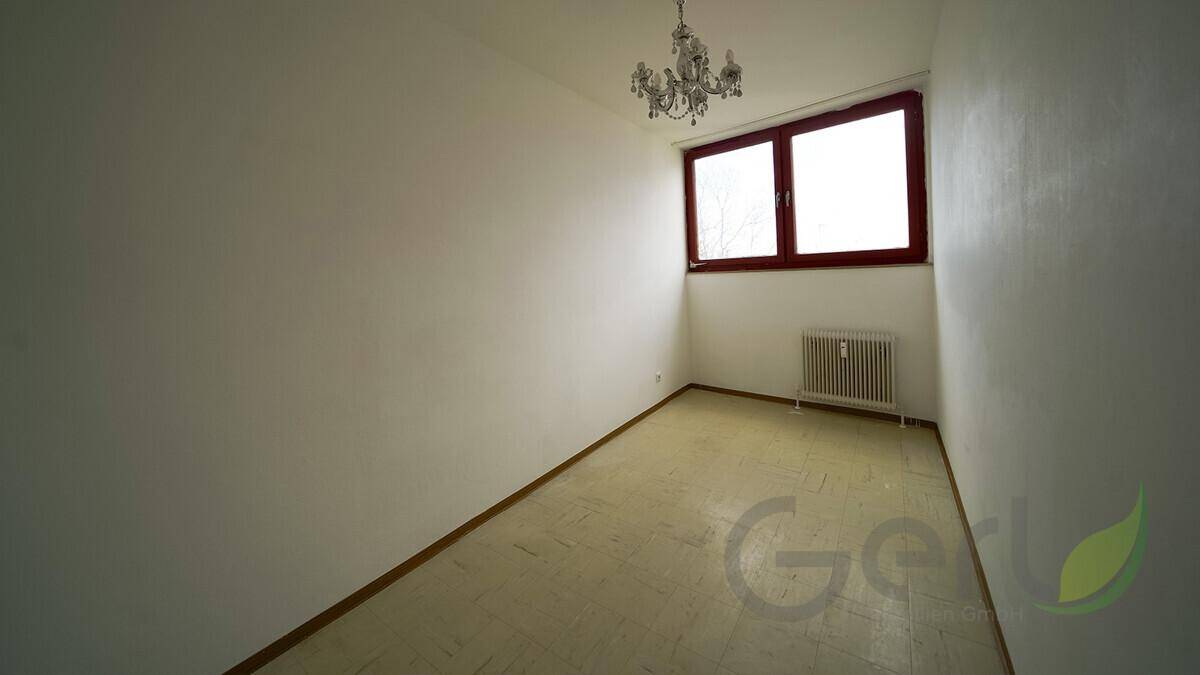 Leeres Zimmer mit Linoleumboden und Fenster, geeignet als Kinder- oder Gästezimmer.