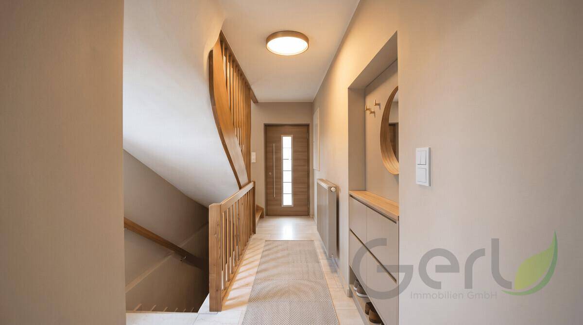 Heller Flur mit Holztreppe und Eingangstür, modern und einladend gestaltet.