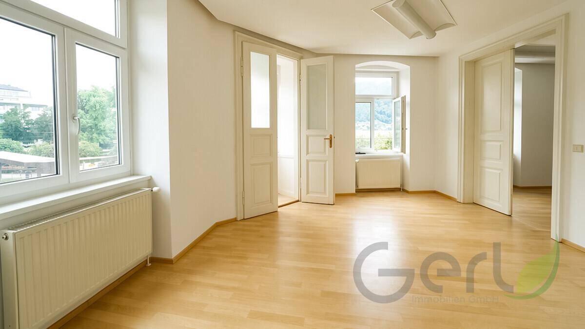 Ruhiges Schlafzimmer mit hellem Holzboden, weißen Wänden und einem Fenster, bereit zur persönlichen Gestaltung.