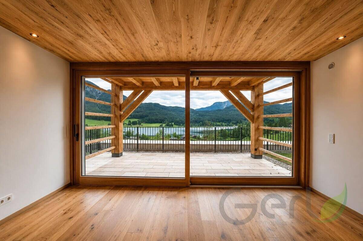 Geräumiger Raum mit Holzboden und Schiebetüren, die zu einer Terrasse mit Seeblick führen.