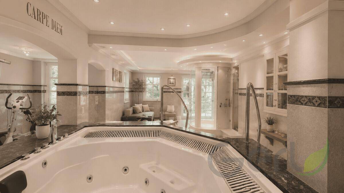 Geräumiger Wellnessbereich mit großem Whirlpool, Fitnessgeräten und entspannender Atmosphäre.