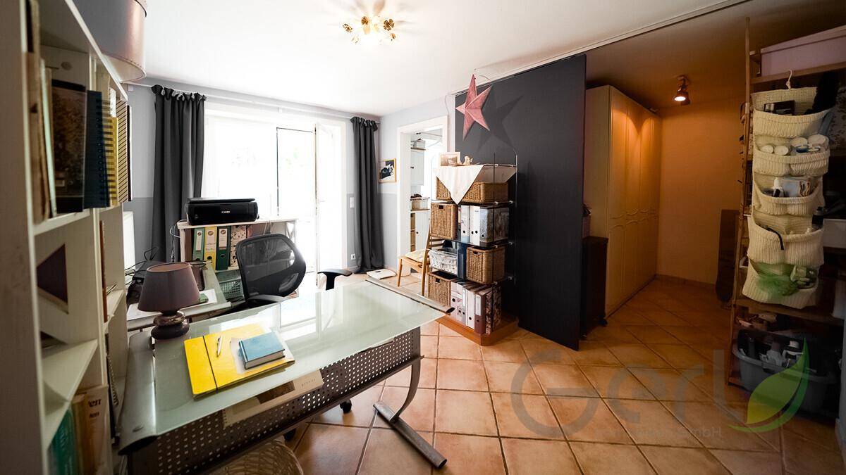 Helles Büro mit Arbeitsplatz, Stauraum und direktem Zugang zu einem sonnigen Außenbereich.