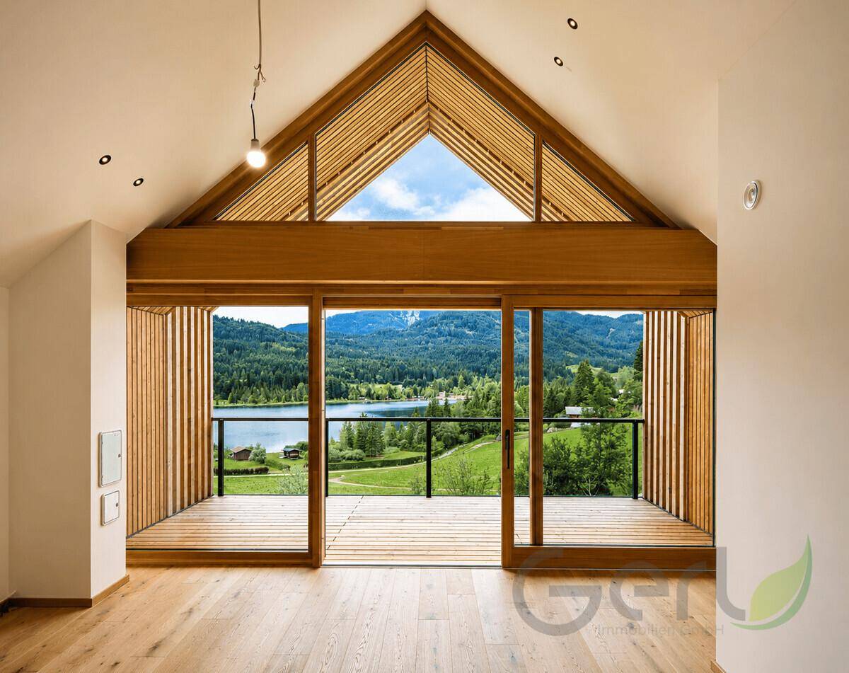 Heller Wohnbereich im Dachgeschoss mit Holzboden, hohen Decken und Zugang zu einem Balkon mit Seeblick.