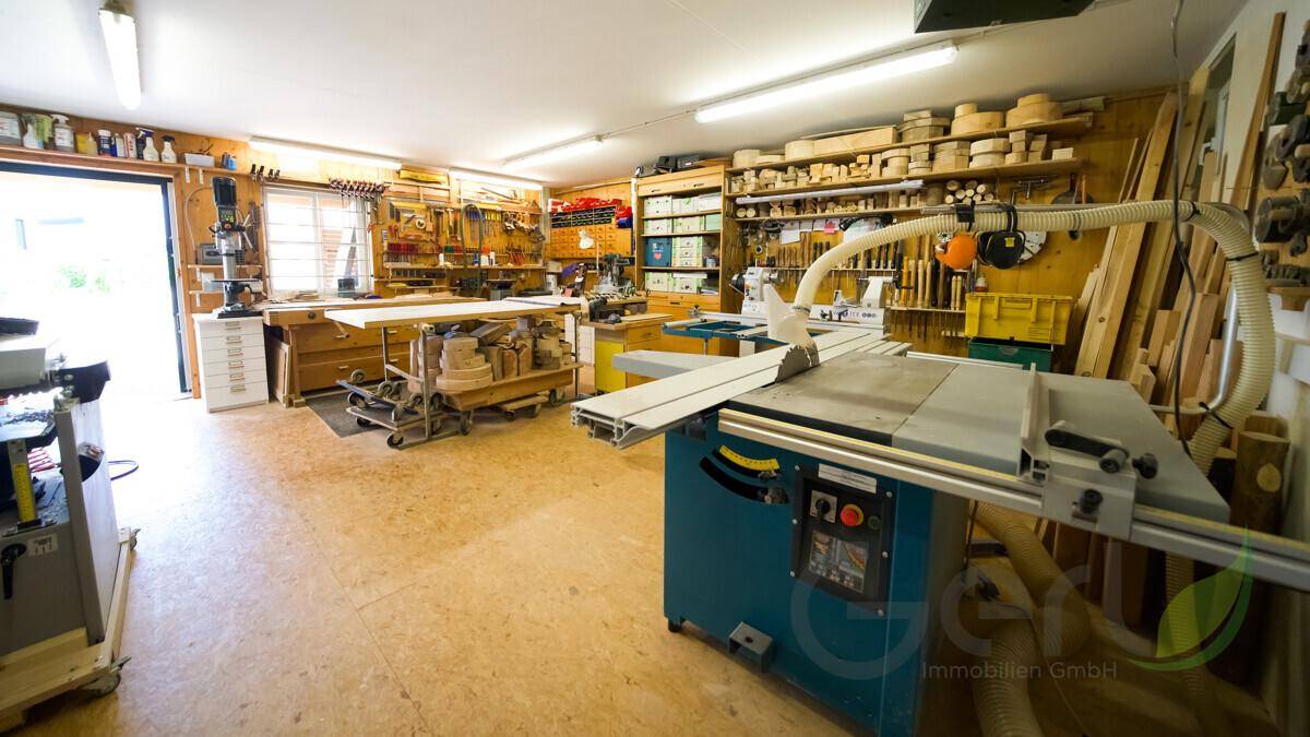 Geräumige Werkstatt mit verschiedenen Holzbearbeitungsmaschinen und Werkzeugen.