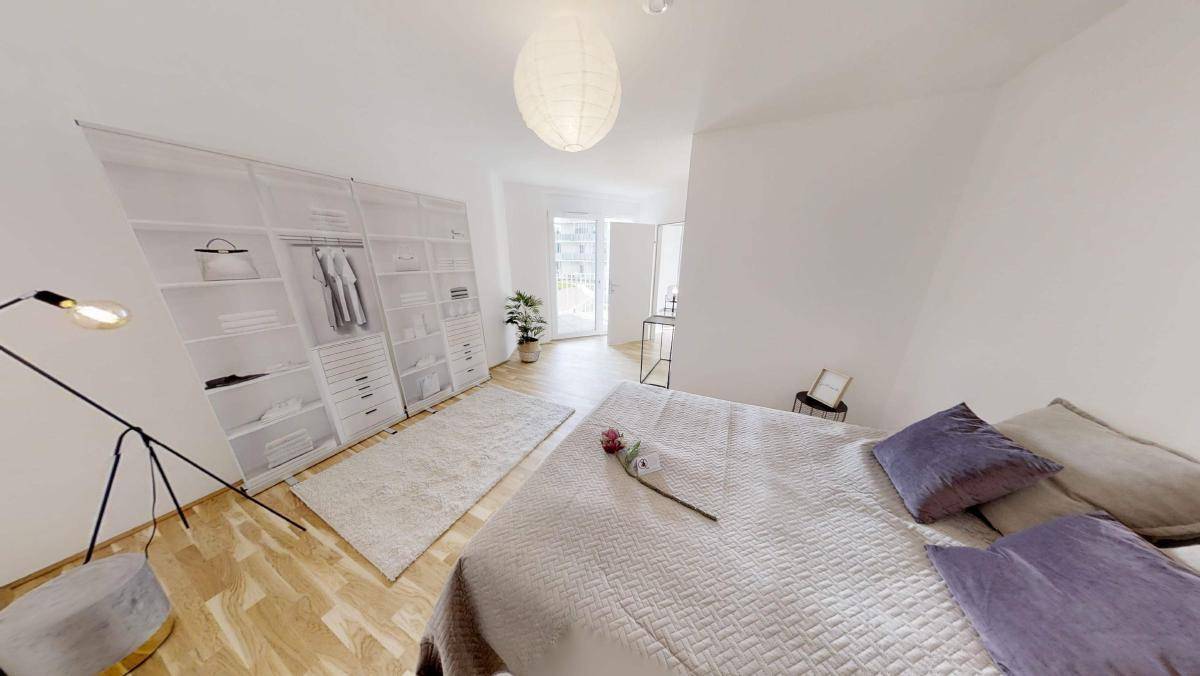 Geräumiges Schlafzimmer mit Holzboden, großem Bett und moderner Stehlampe.