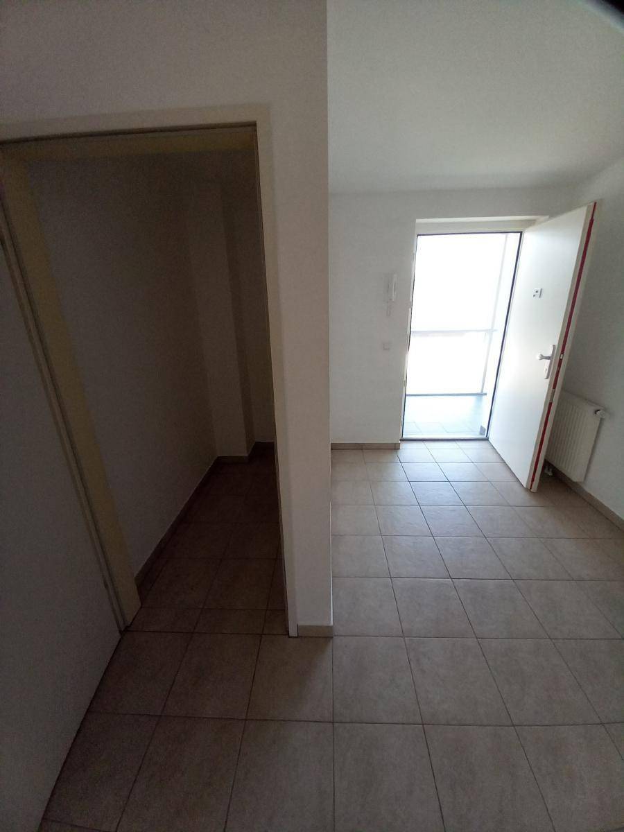 Eingangsbereich mit Fliesenboden und offener Haustür, die viel Tageslicht hereinlässt.