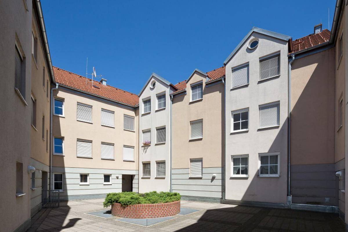 Innenhof des Gebäudekomplexes mit kleiner Grünfläche und umliegenden Fassaden.