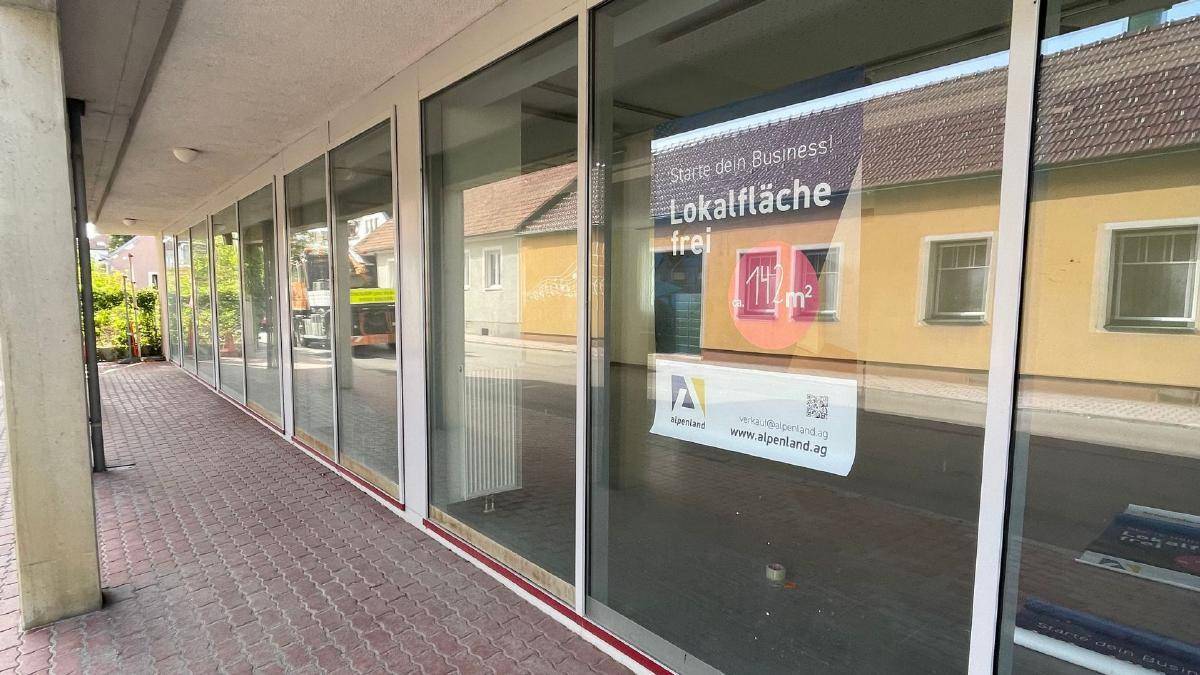 Außenansicht der Geschäftsfläche mit großen Schaufenstern und einem Werbeschild für die Vermietung.