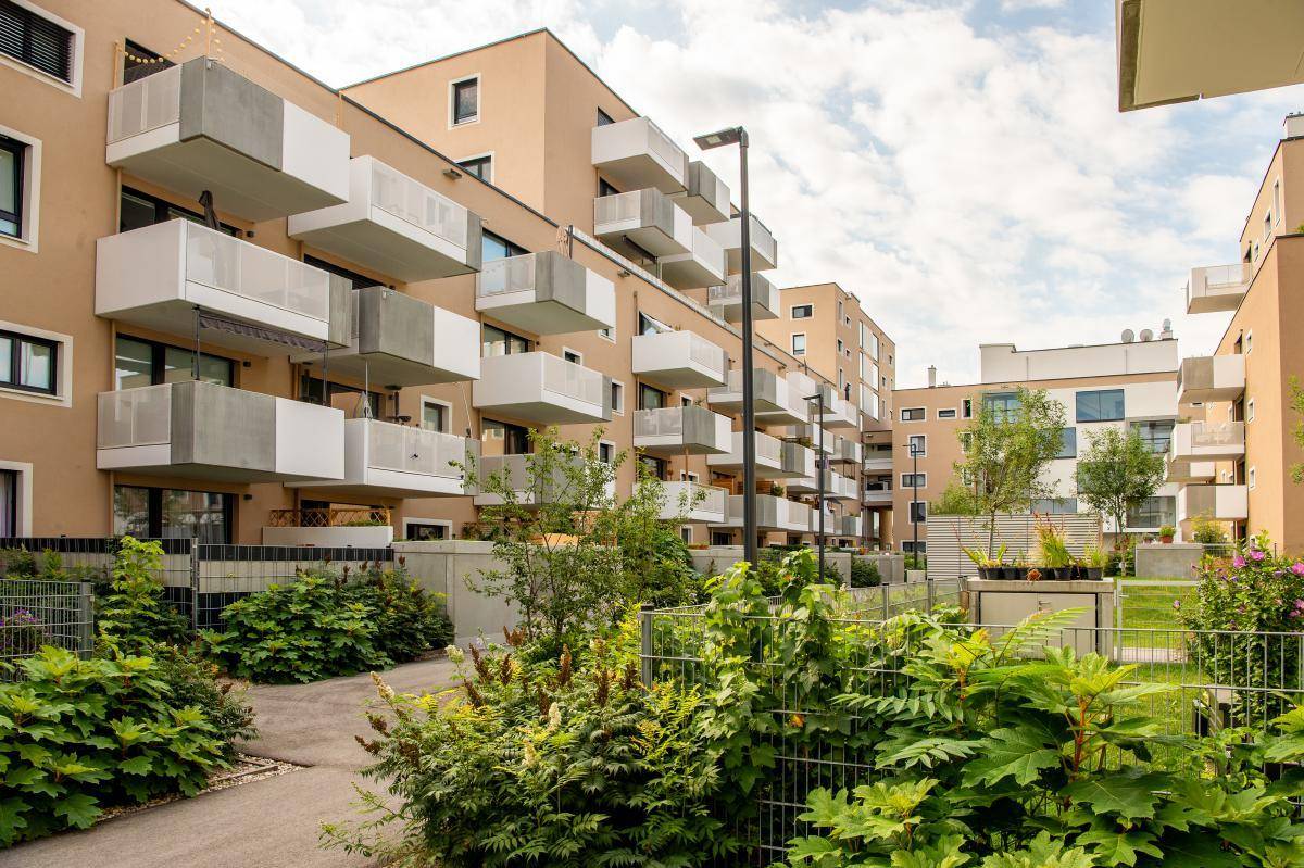 Moderne Wohngebäude mit Balkonen und gepflegten Grünflächen im Vordergrund, die zum Verweilen einladen.