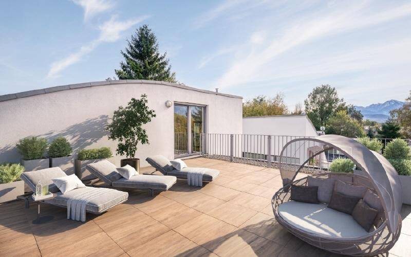 Weitläufige Dachterrasse mit Sonnenliegen und Lounge-Möbeln, bietet einen weiten Blick.