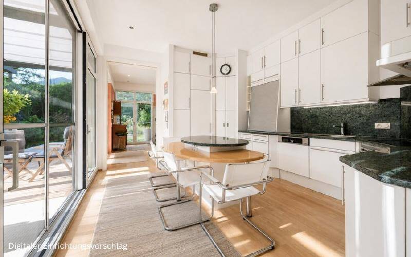 Helle, moderne Küche mit weißen Schränken, dunkler Arbeitsplatte und Essbereich mit Zugang zur Terrasse.