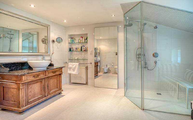 Modernes Badezimmer mit begehbarer Dusche, stilvollem Waschtisch und großem Spiegel.