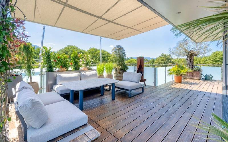 Geräumige Terrasse mit bequemen Outdoor-Möbeln, Sonnenschutz und weitem Blick ins Grüne.