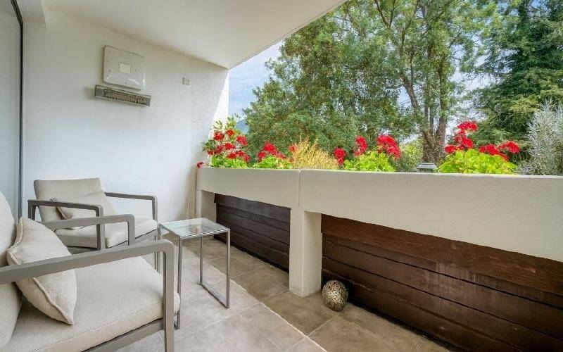Gemütlicher Balkon mit Sitzgelegenheiten, Blumenkästen und Blick ins Grüne.