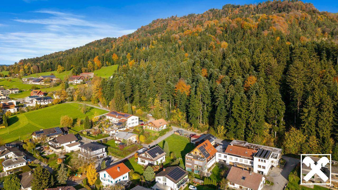 Wohnsiedlung am Fuße eines bewaldeten Berges mit vielen Einfamilienhäusern.