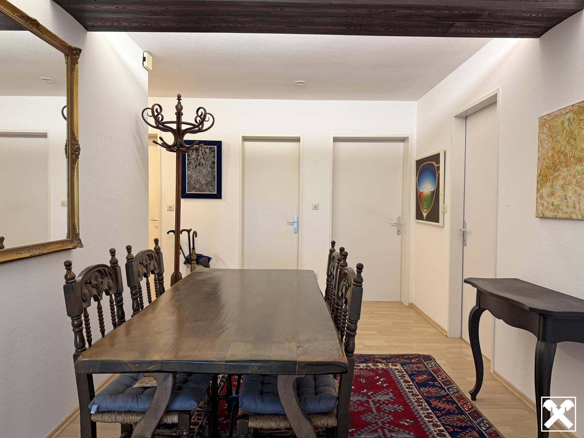 Essbereich mit rustikalem Holztisch, passenden Stühlen und sichtbaren Deckenbalken.