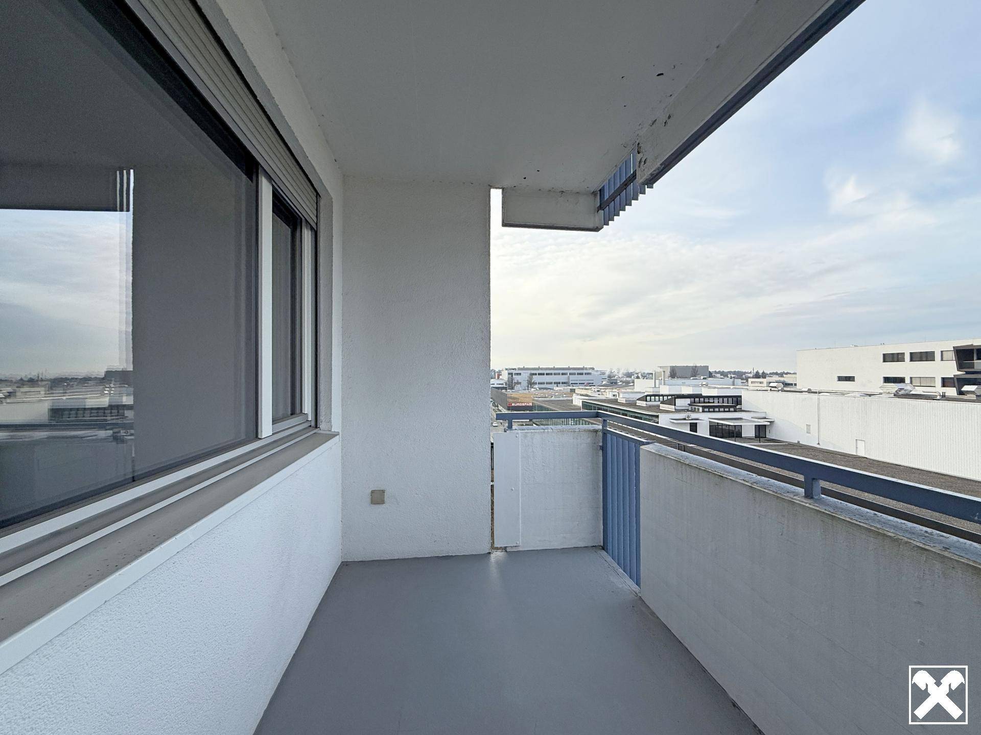 Balkon mit Blick auf umliegende Gebäude und eine städtische Umgebung.