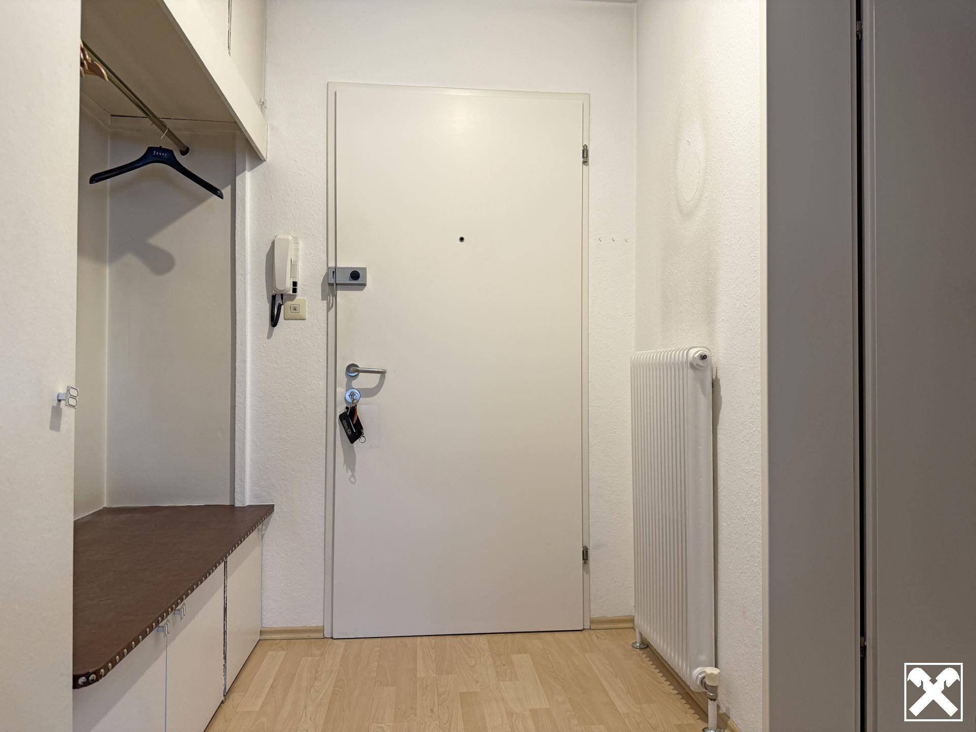 Eingangsbereich mit Garderobe, Einbauschränken und heller Laminatboden.