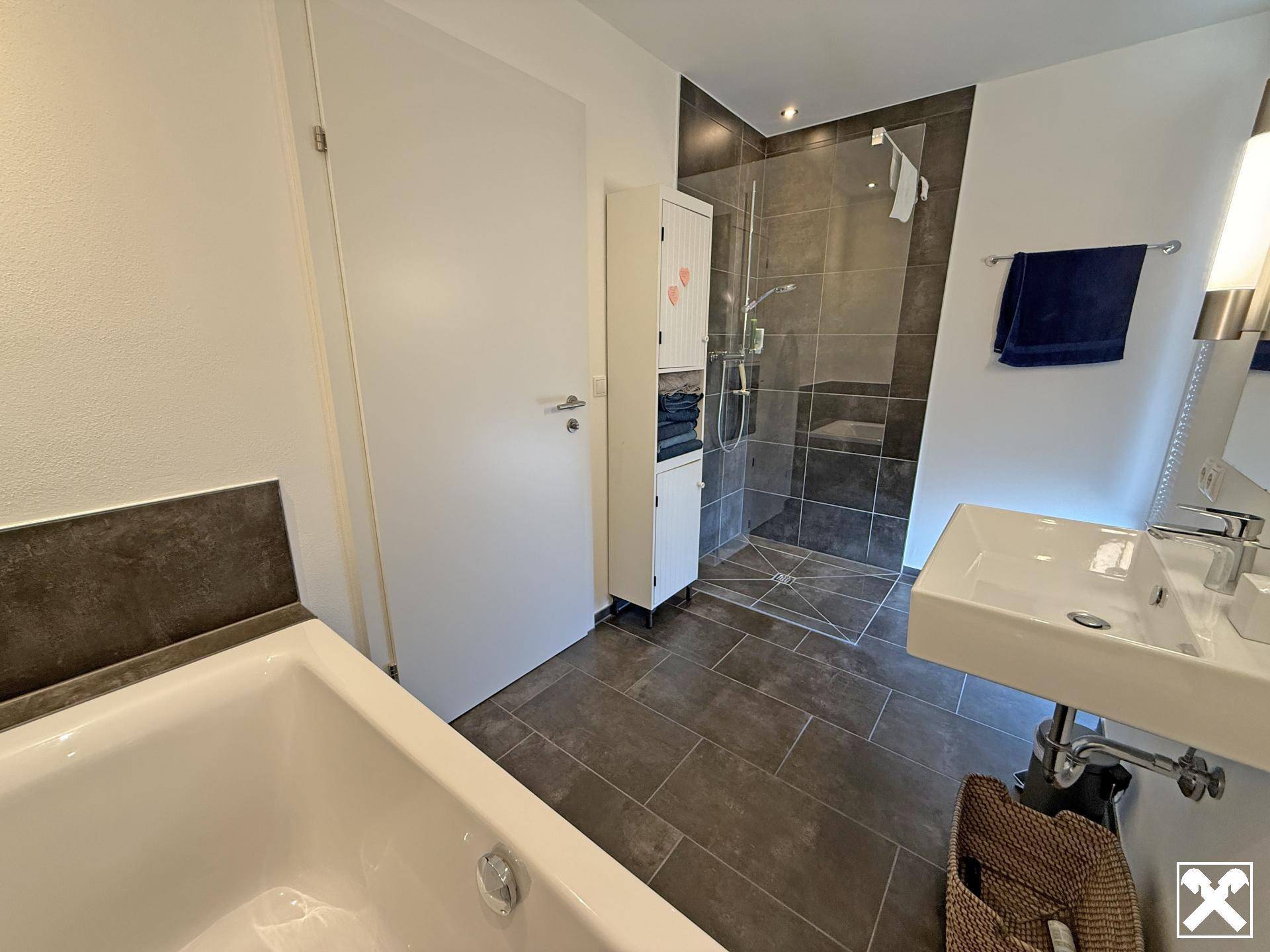 Modernes Badezimmer mit Badewanne, ebenerdiger Dusche und stilvollen grauen Fliesen und einem Einzelwaschbecken.
