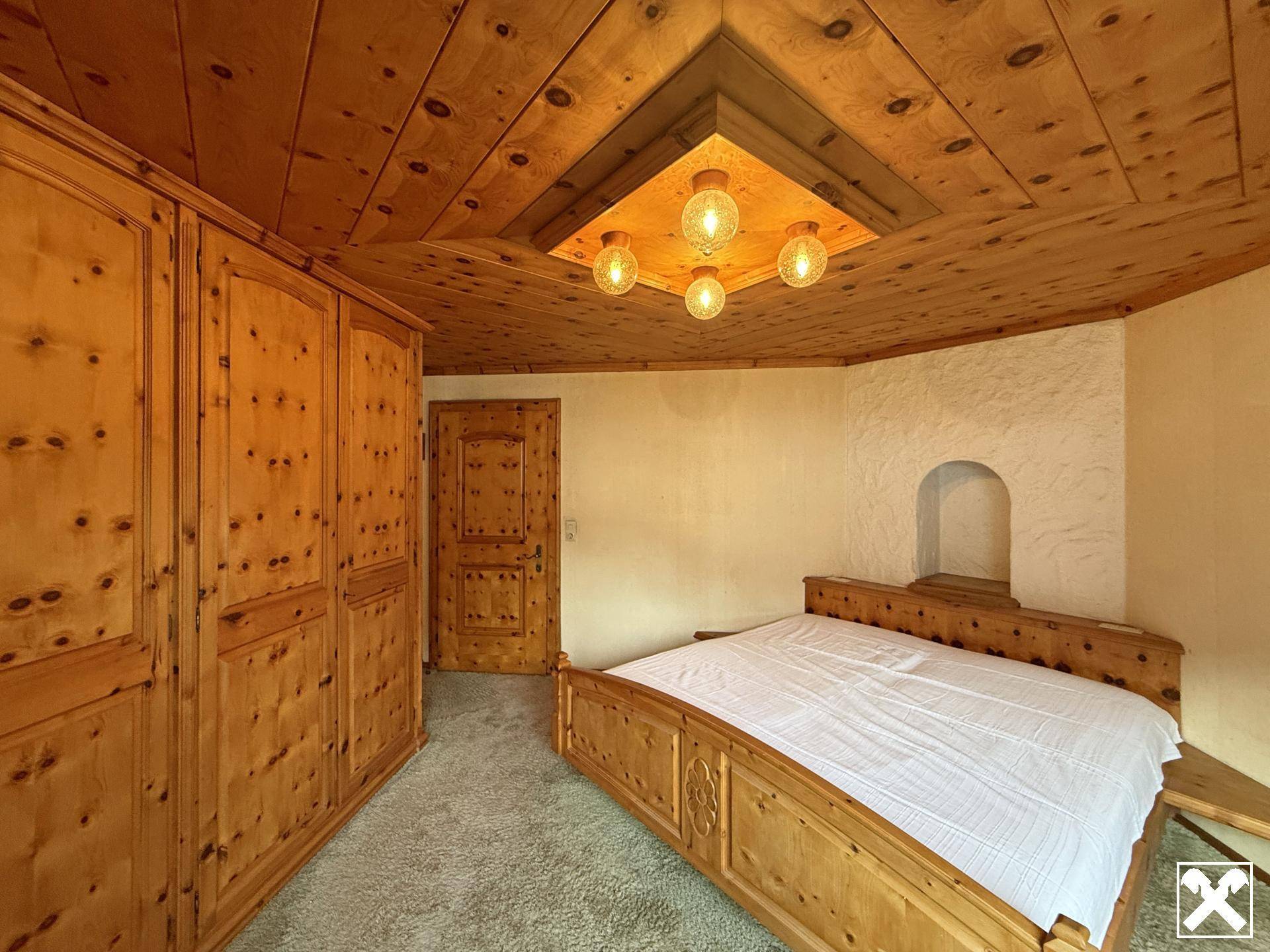 Schlafzimmer mit Holztäfelung, Einbauschränken und rustikalem Charme.