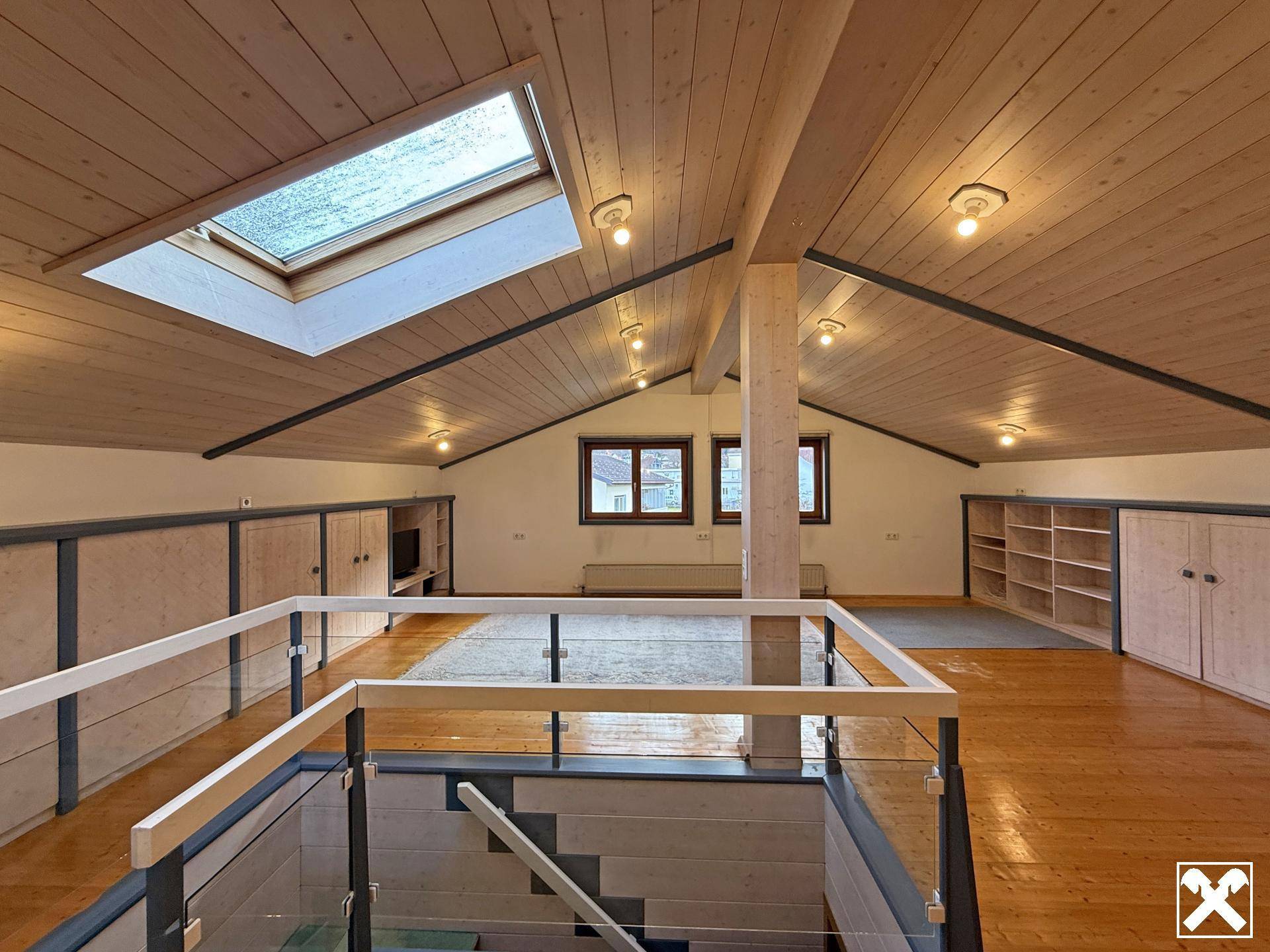 Offener Dachgeschossbereich mit Holzbalkendecke, Dachfenster und Galerie.