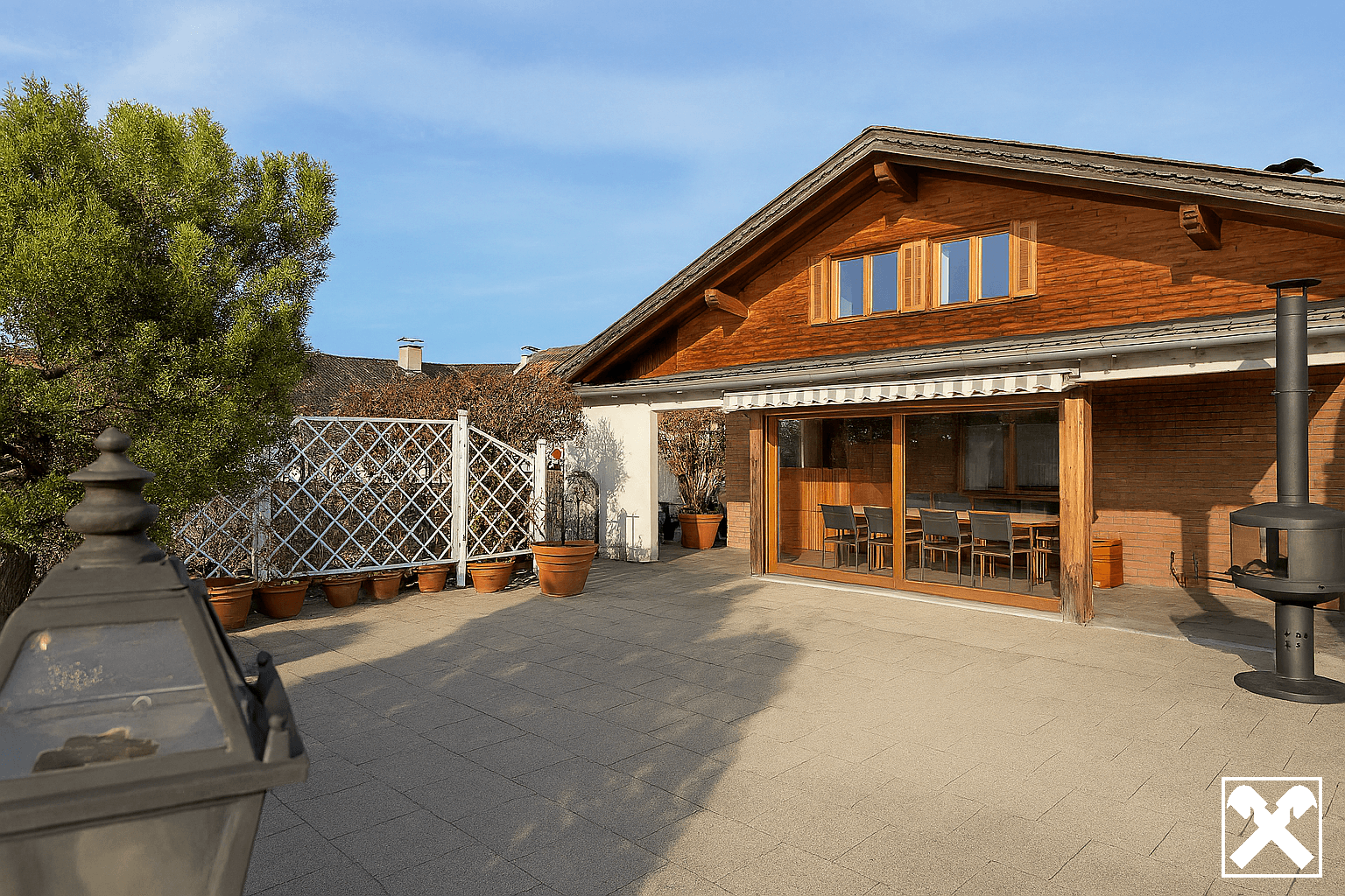Große gepflasterte Terrasse mit Essbereich im Freien und Zugang zum Haus.