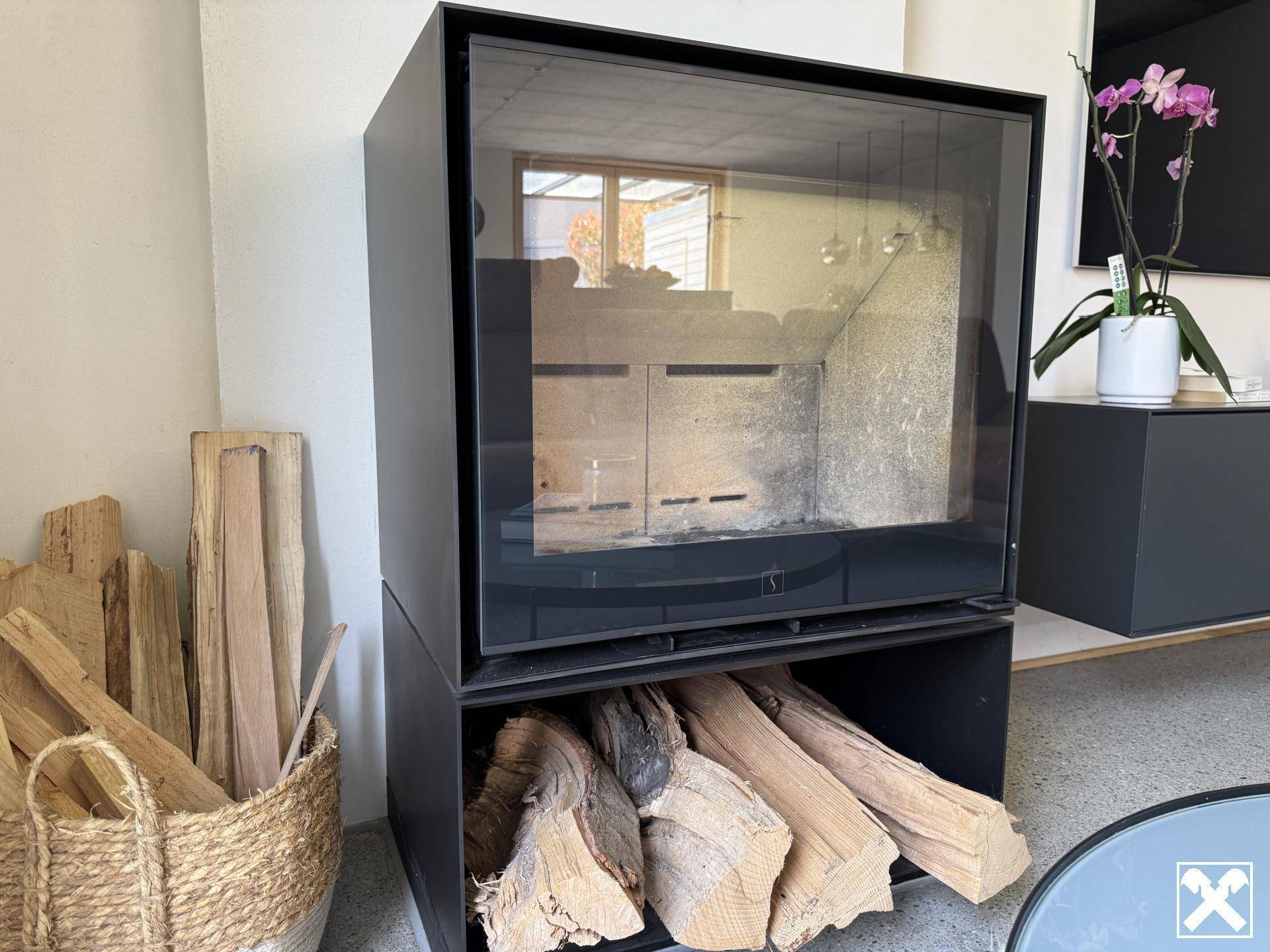 Moderner Kaminofen mit Holzscheiten und Glasfront für gemütliche Abende.
