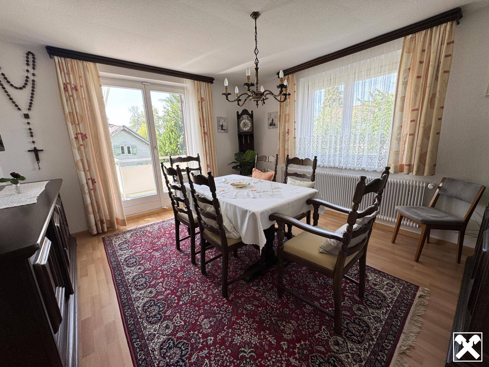 Gemütliches Esszimmer mit Holzboden, großem Esstisch und Zugang zum Außenbereich.