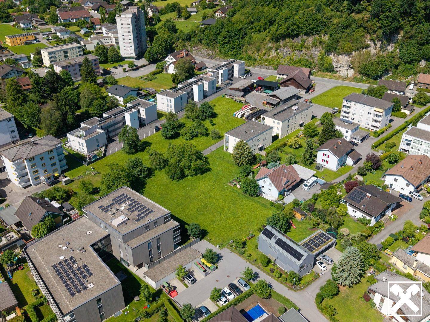 Überblick aus der Vogelperspektive über eine Wohnsiedlung mit viel Grünfläche und verschiedenen Gebäudetypen.