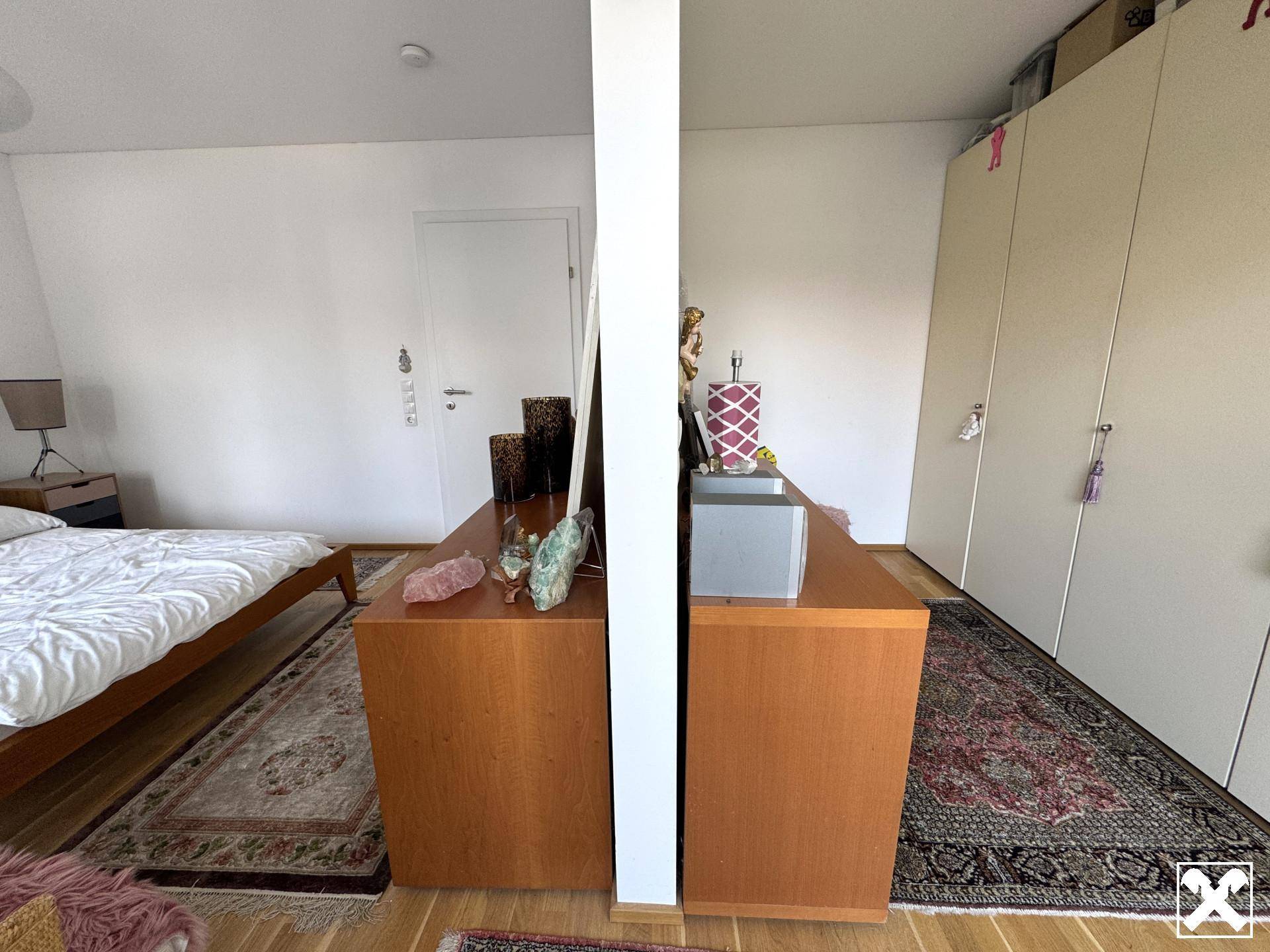 Schlafzimmer mit integriertem Stauraum und Kleiderschrank, ergänzt durch einen Holzboden.