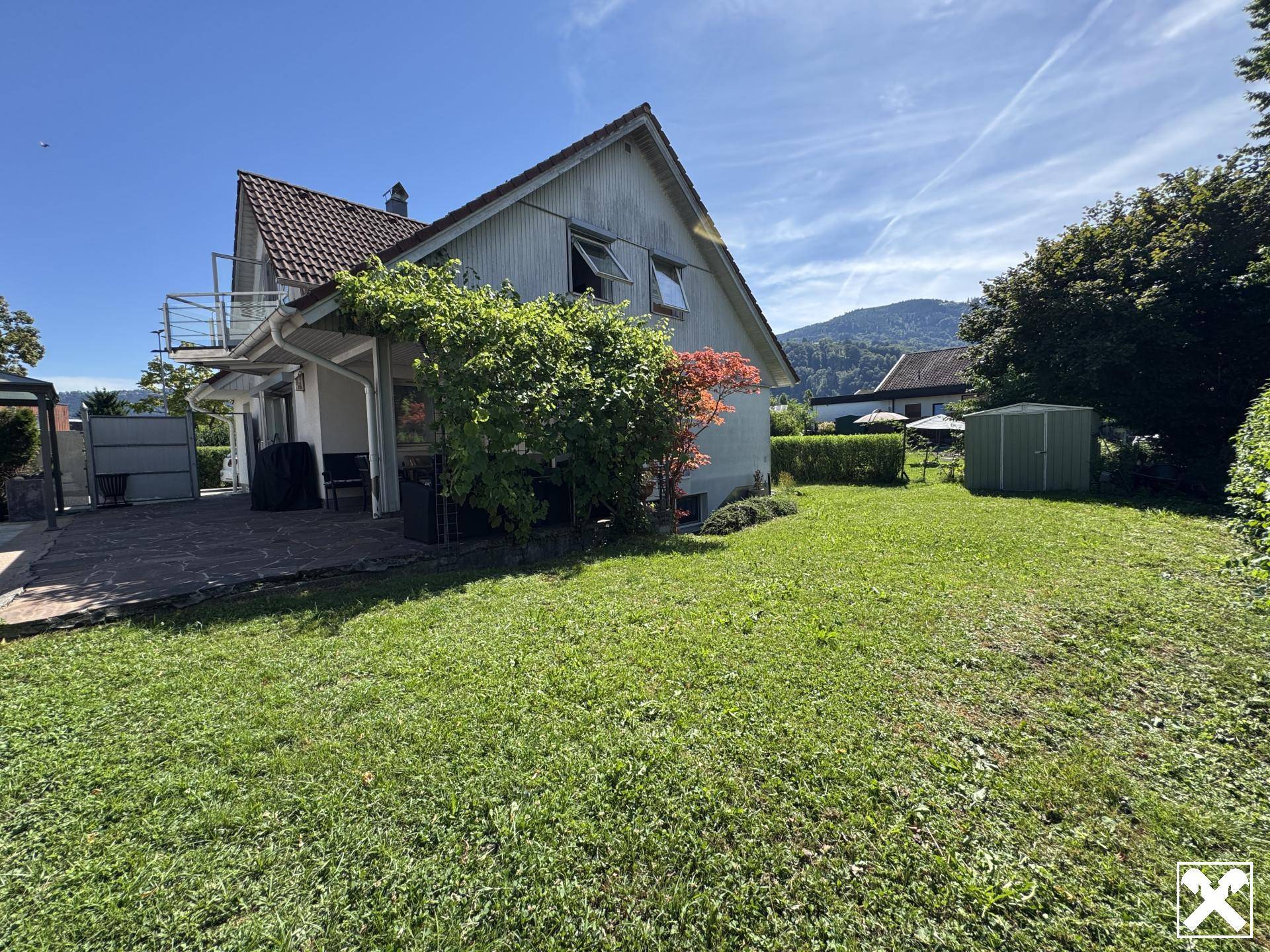 Großer grüner Garten mit Rasenfläche und Blick auf die umliegende Hügellandschaft.
