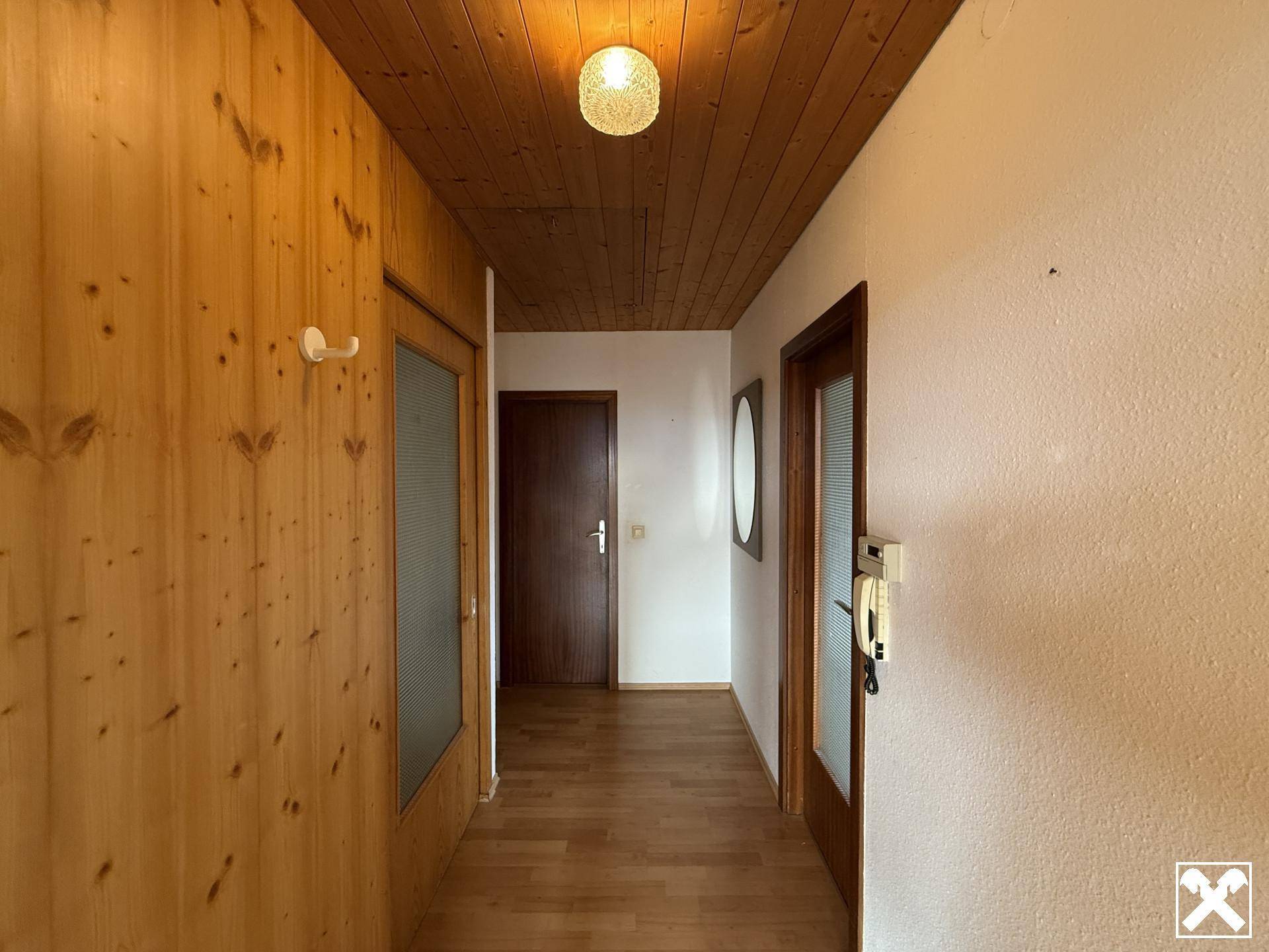 Gemütlicher Flur mit Holzvertäfelung, Holzdecke und passendem Holzboden.