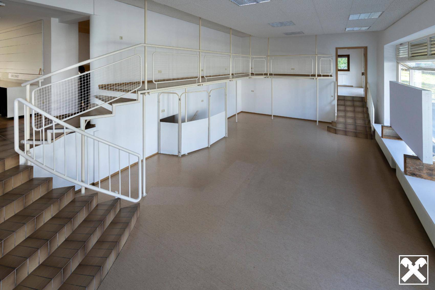 Großer offener Raum mit Treppe und Geländer, ideal für Büro- oder Verkaufsflächen.