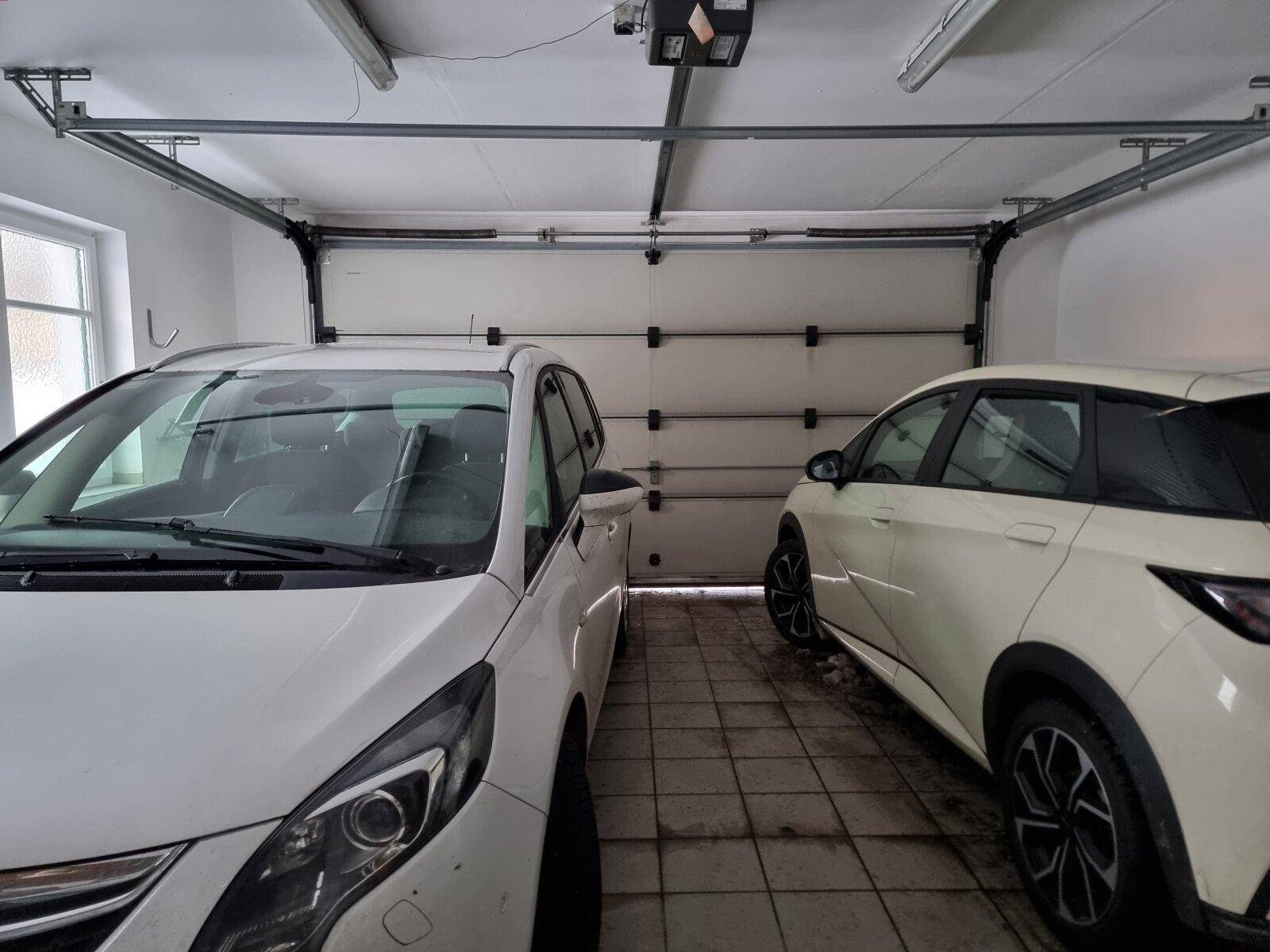 Doppelgarage mit zwei Fahrzeugen und automatischem Garagentor.