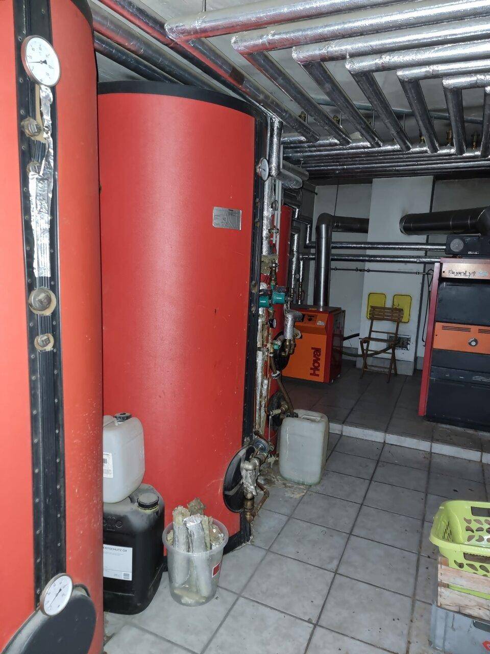 Heizungsraum mit großen Warmwasserspeichern und komplexer Rohrinstallation.
