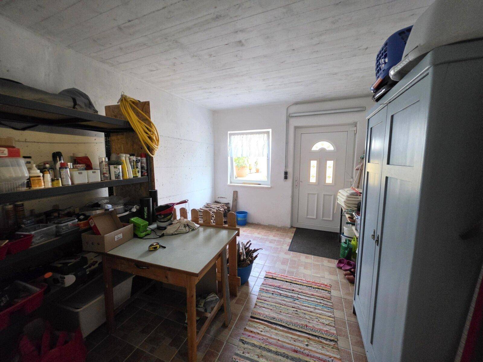 Praktischer Hauswirtschaftsraum mit Regalen und Arbeitsfläche, ideal für Hobby und Lagerung.