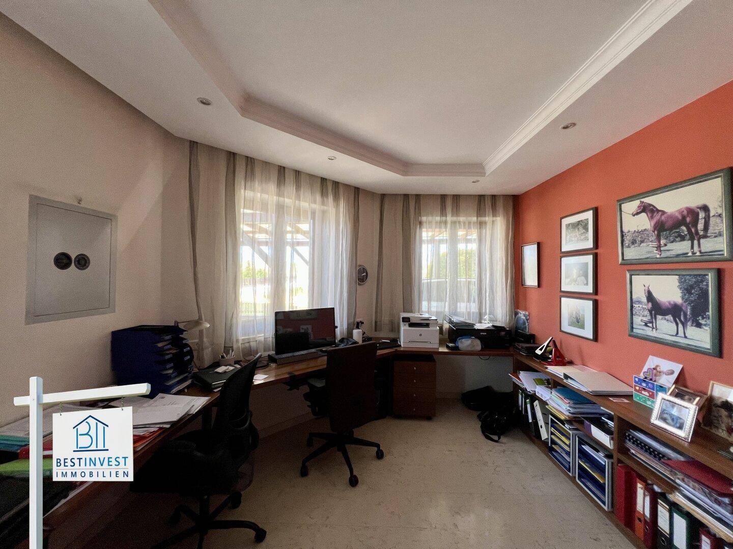 Funktionales Heimbüro mit mehreren Arbeitsplätzen, Stauraum und viel natürlichem Licht durch große Fenster.