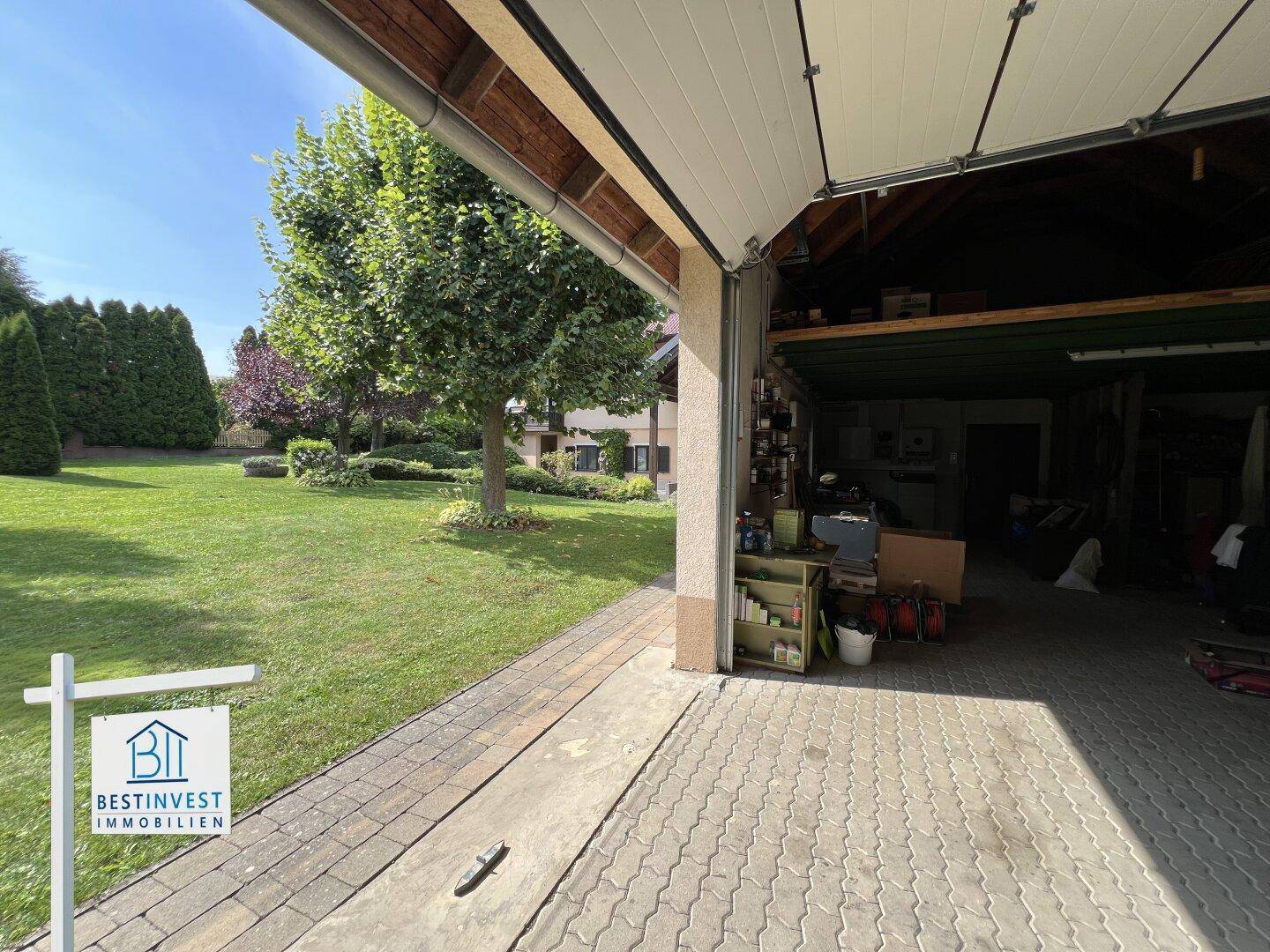 Geräumige Garage mit offenem Tor und angrenzendem gepflegten Rasenbereich.