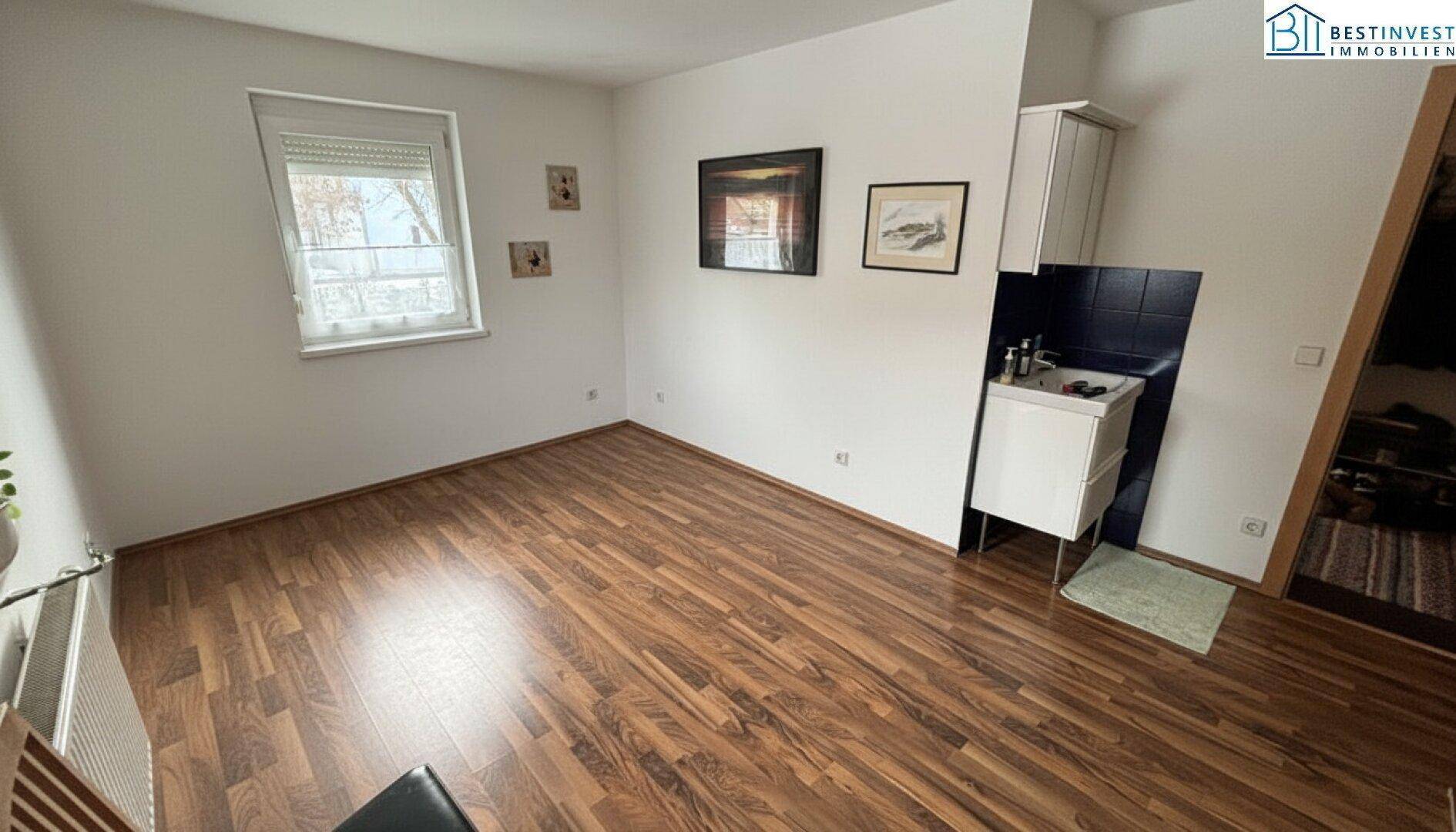 Einfacher Raum mit Laminatboden und einem Waschbecken, ideal als Hauswirtschaftsraum.