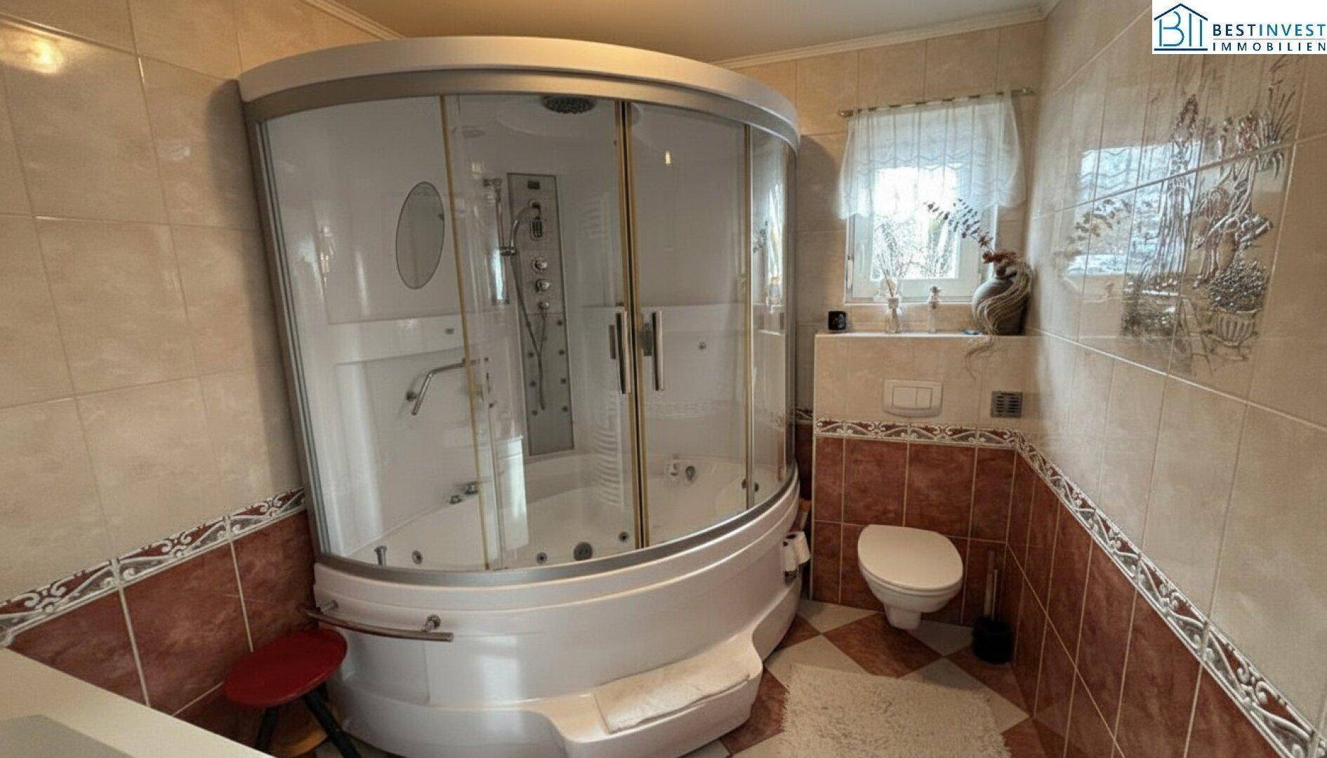 Badezimmer mit großer Duschkabine, integriertem Whirlpool und Wand-WC.