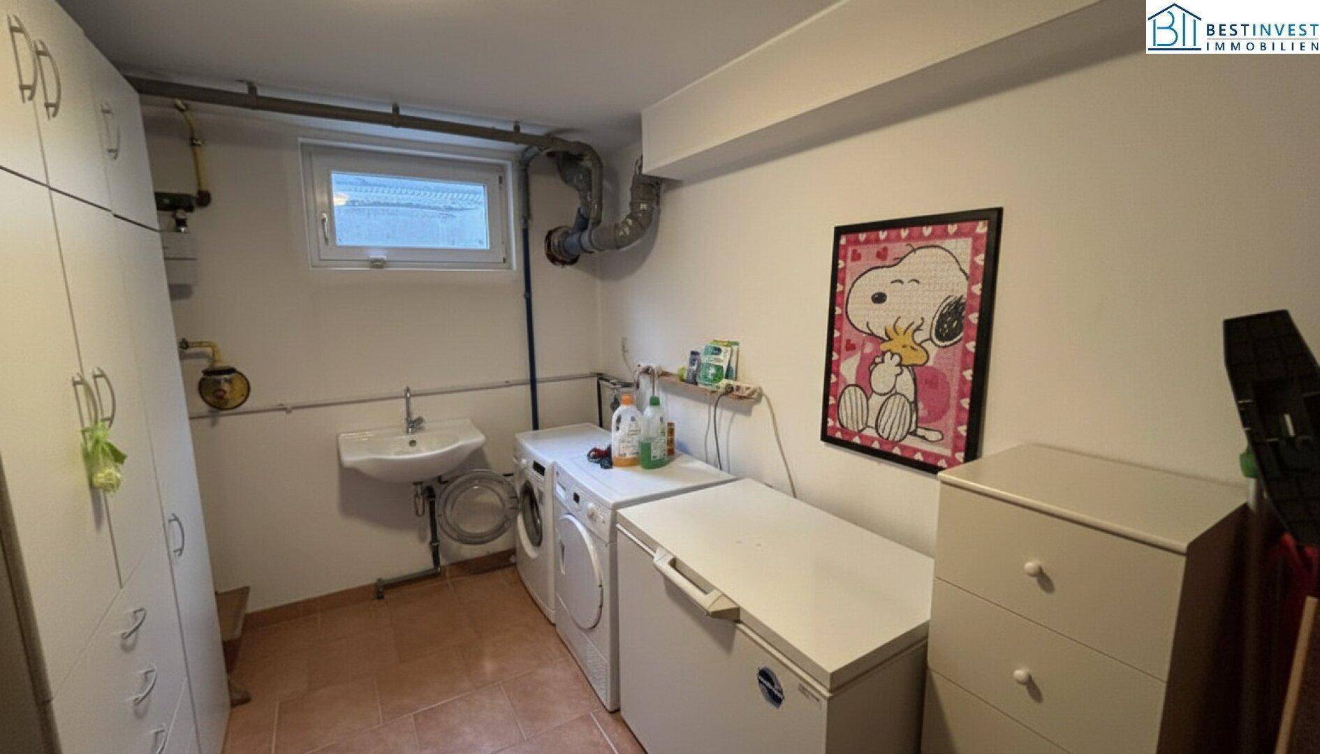 Hauswirtschaftsraum im Keller mit Waschmaschine, Trockner und Stauraum.