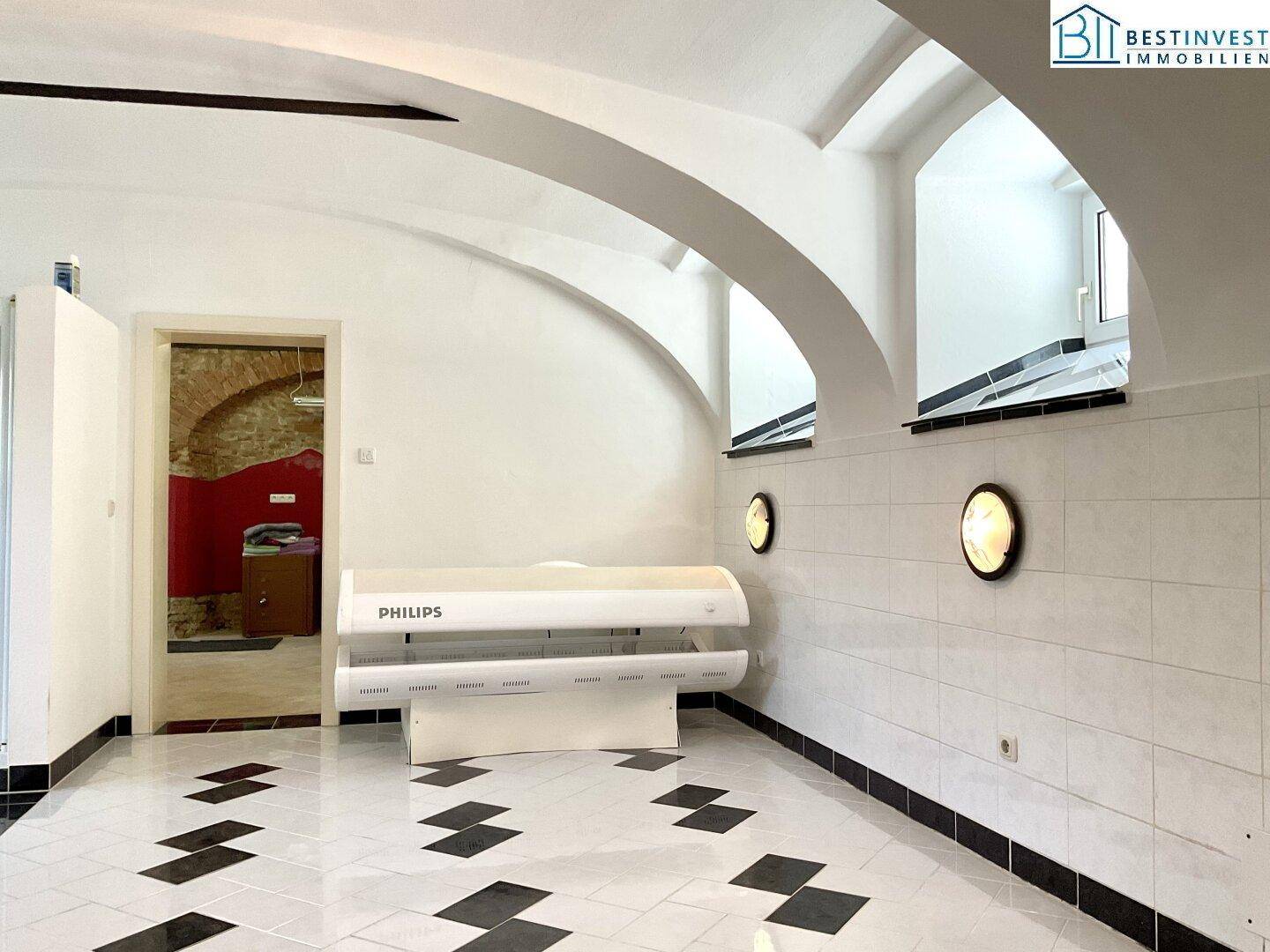Raum mit gewölbter Decke, weißen Fliesen und einem Solarium, ideal für einen Wellnessbereich.