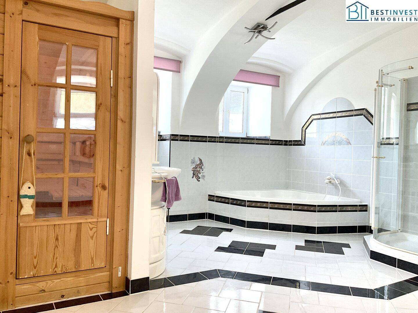 Geräumiges Badezimmer mit Eckbadewanne, Dusche, gewölbter Decke und dekorativen Fliesen.