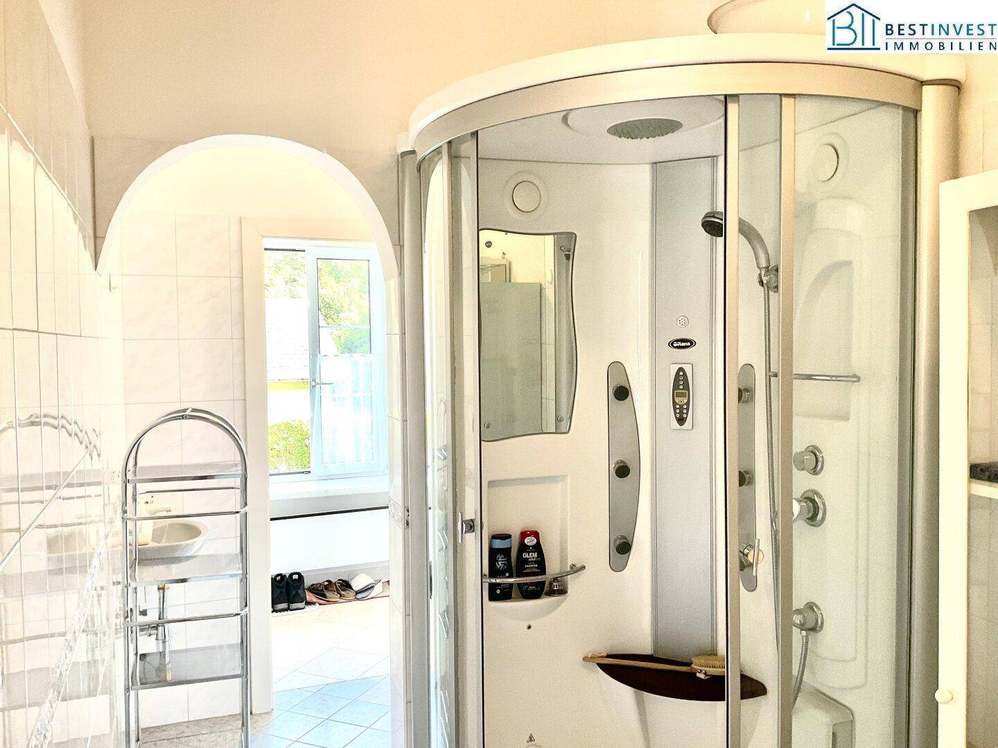 Badezimmer mit moderner Duschkabine, Fliesenboden und hellem Ambiente.