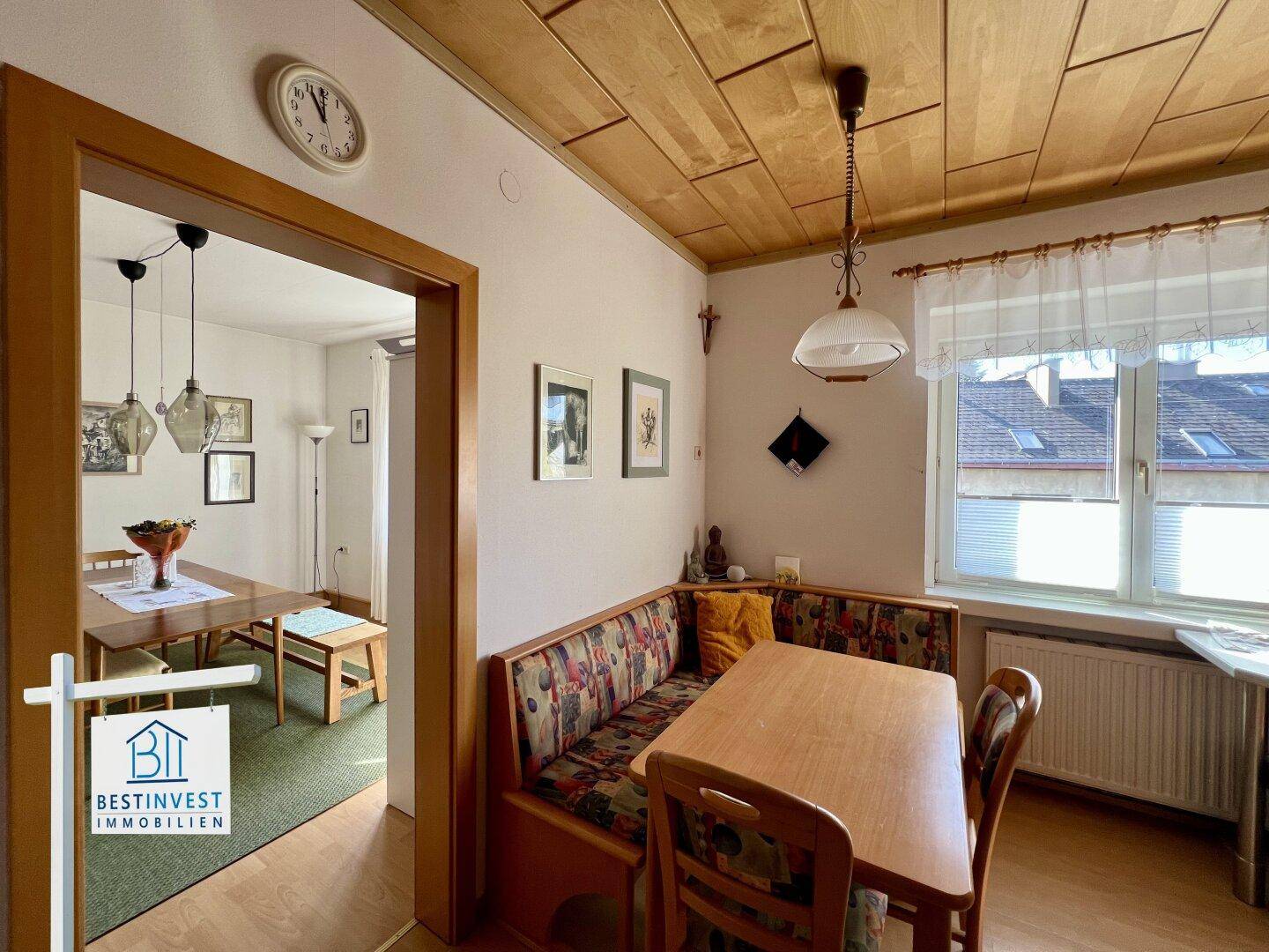 Gemütlicher Essbereich mit Holztäfelung an der Decke und Blick in ein weiteres Zimmer.
