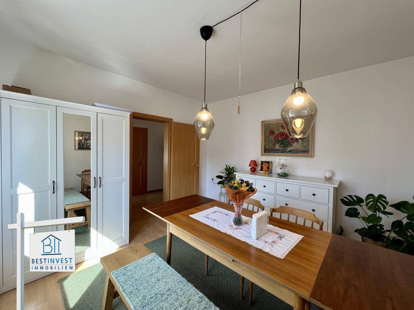Geräumiger Essbereich mit Holztisch, Sitzbank und modernem Beleuchtungskonzept in hellem Ambiente.