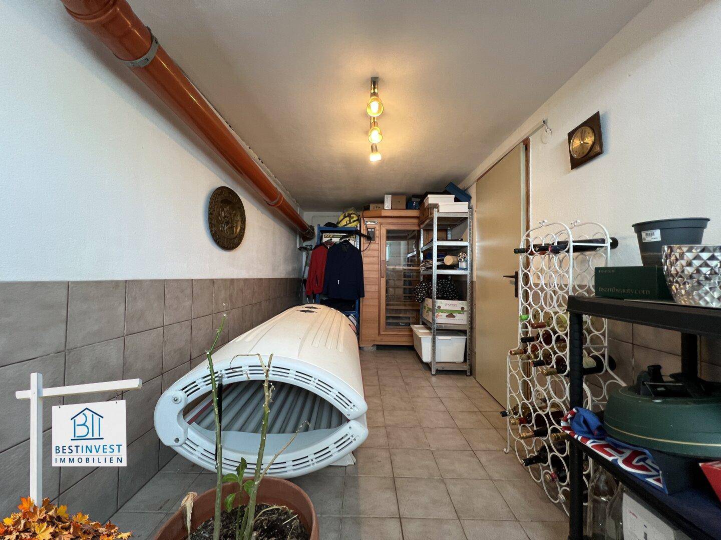 Geräumiger Abstellraum im Keller mit Fliesenboden, Weinregalen und einem Solarium.