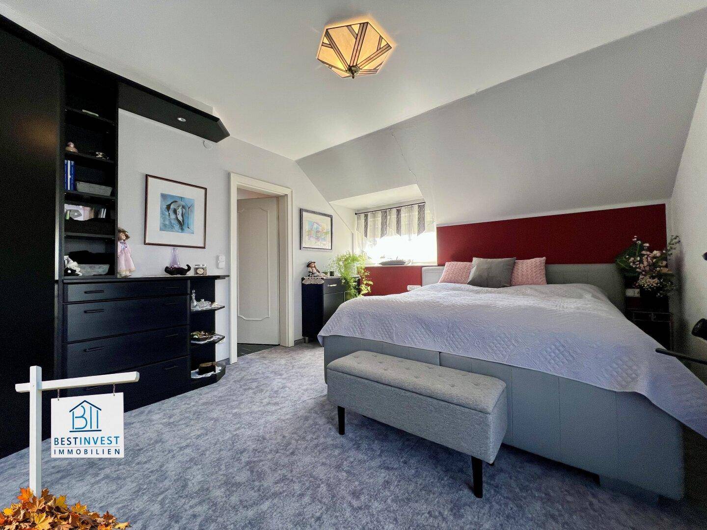 Helles Schlafzimmer mit Doppelbett, Einbauschränken und Dachschräge, modern und funktional.